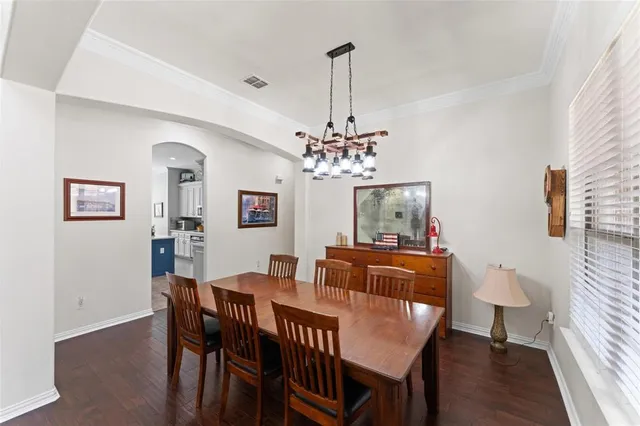a view of a dining room with furniture a chandelier and wooden floor