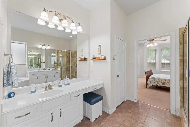 a spacious en suite bathroom with a double vanity sink and mirror