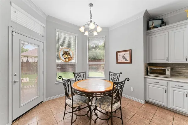 a dining room with chandelier and wooden floor