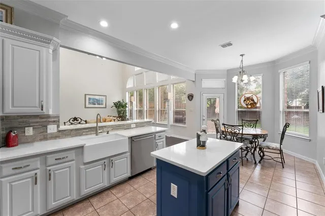 a kitchen with sink a refrigerator and chairs