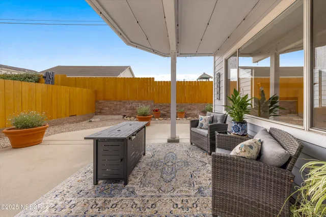 a living room with furniture a flat screen tv and a floor to ceiling window