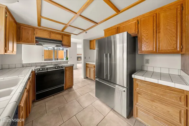 a kitchen with granite countertop a refrigerator stove and sink