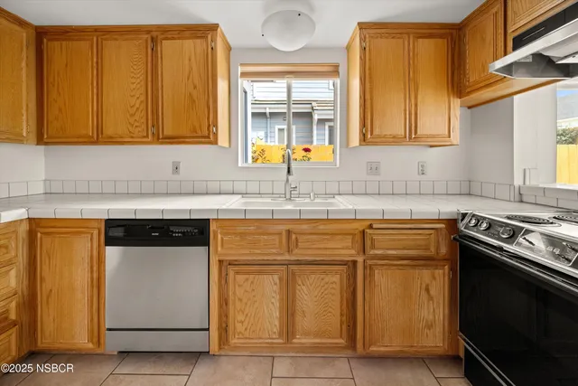 a kitchen with granite countertop a sink stainless steel appliances and cabinets
