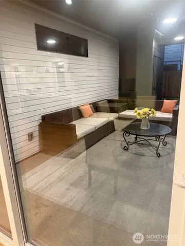 a living room with couches and kitchen view with wooden floor