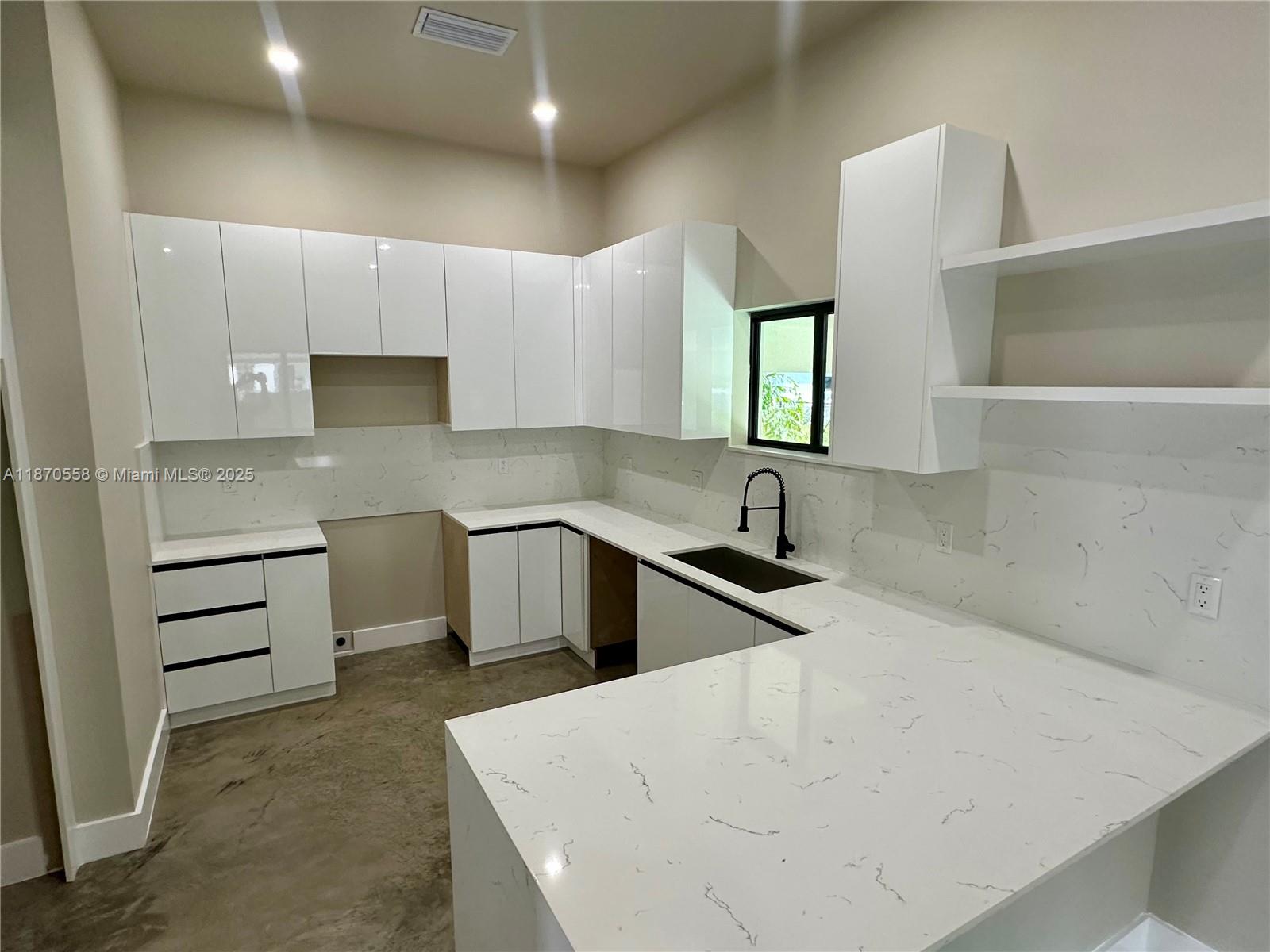 929 Northwest 60th Street Miami, FL 33127 - Photo 12 of 58 a kitchen with a sink a stove and cabinets