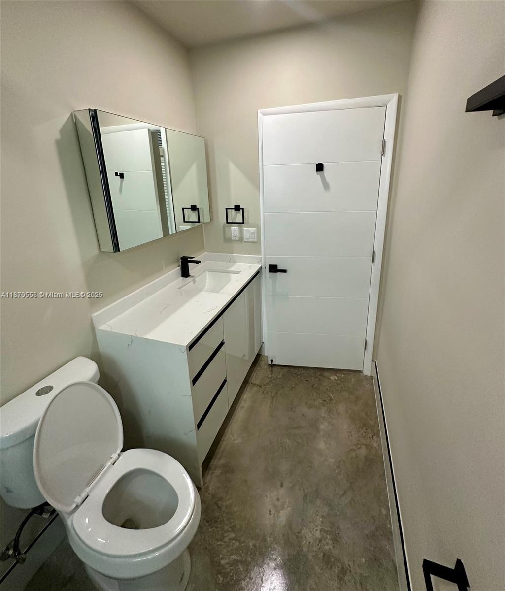 929 Northwest 60th Street Miami, FL 33127 - Photo 30 of 58 a bathroom with a toilet sink and mirror