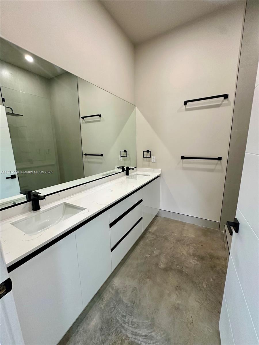 929 Northwest 60th Street Miami, FL 33127 - Photo 35 of 58 a bathroom with a double vanity sink a mirror and a shower