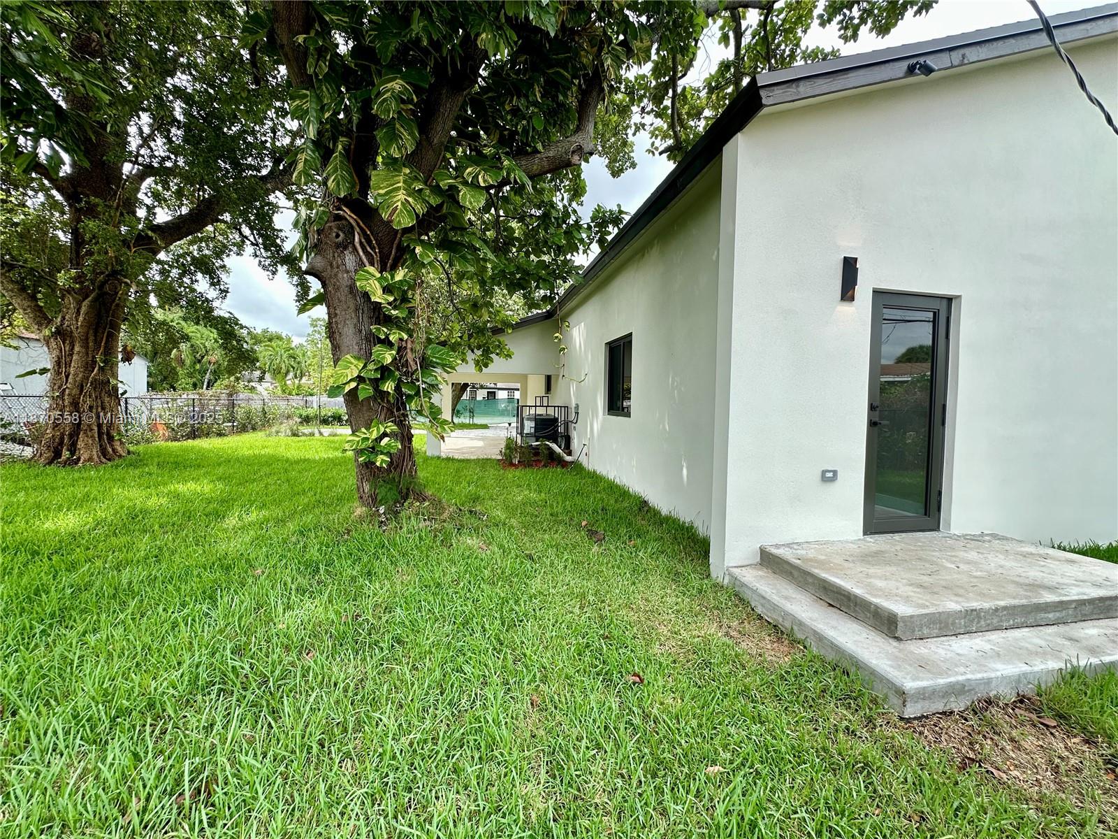 929 Northwest 60th Street Miami, FL 33127 - Photo 45 of 58 a view of a backyard with a garden and trees