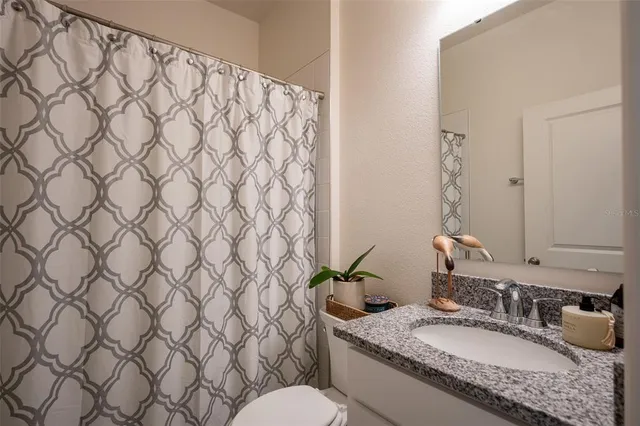 a spacious bathroom with a double vanity sink toilet mirror and shower
