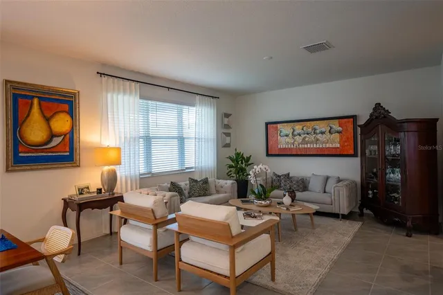 a living room with furniture a bookshelf and a window