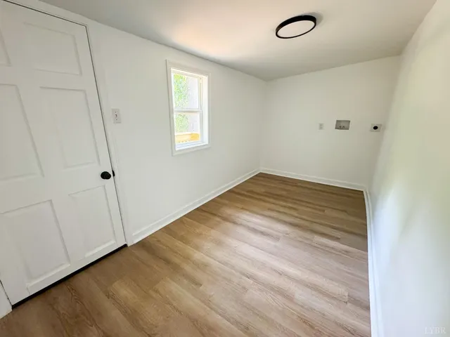 a view of a room with wooden floor and white walls