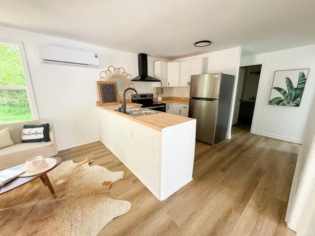a kitchen with refrigerator cabinets and wooden floor