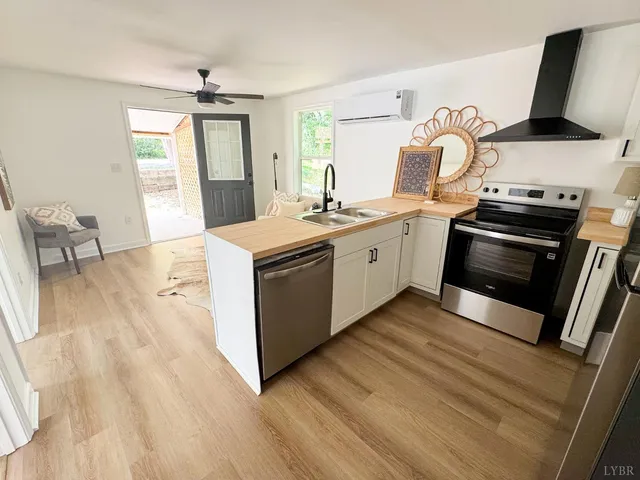 a kitchen with stainless steel appliances a stove a sink and white cabinets
