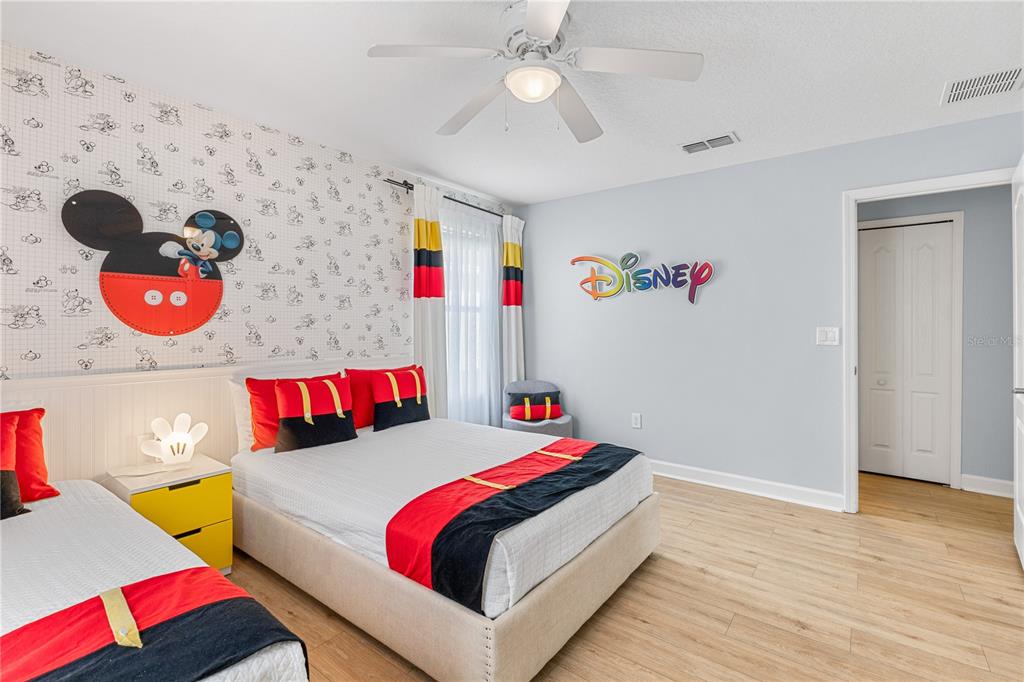 9006 Majesty Palm Road Kissimmee, FL 34747 - Photo 50 of 56 a bedroom with a bed and a chandelier
