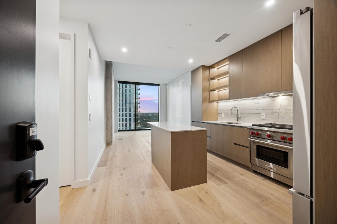 a kitchen with granite countertop a stove and a refrigerator