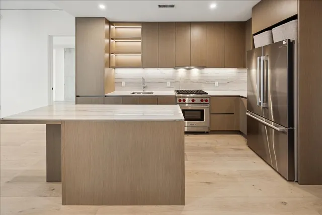 a kitchen with stainless steel appliances granite countertop a refrigerator and a stove
