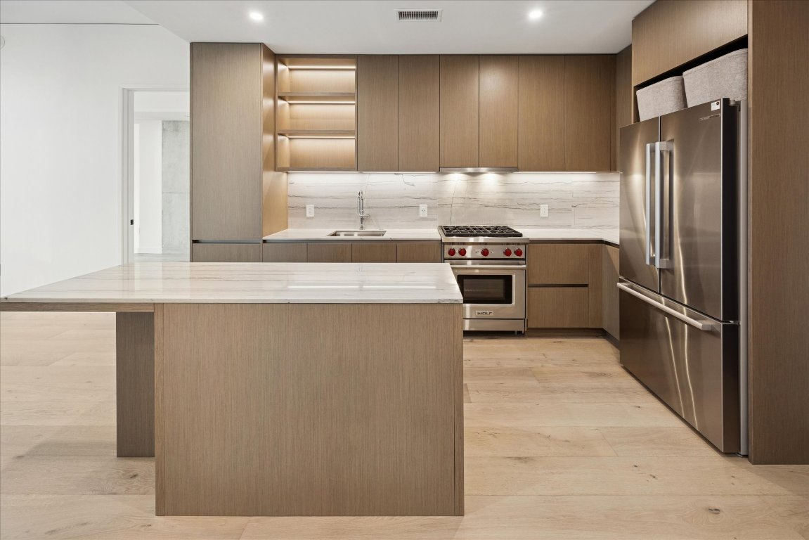610 Davis Street, Unit 3204 Austin, TX 78701 - Photo 3 of 27 a kitchen with stainless steel appliances granite countertop a refrigerator and a stove