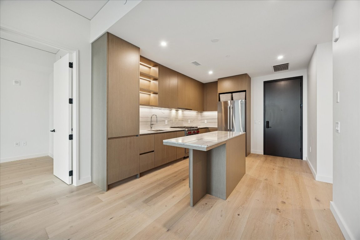 610 Davis Street, Unit 3204 Austin, TX 78701 - Photo 6 of 27 a kitchen with stainless steel appliances granite countertop a refrigerator a sink and a stove