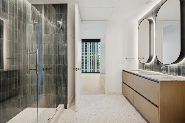 a bathroom with a granite countertop sink a mirror and shower