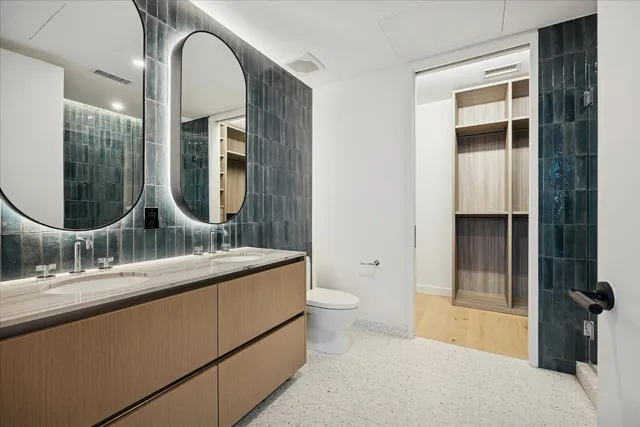 a en suite bathroom with a granite countertop sink and a mirror