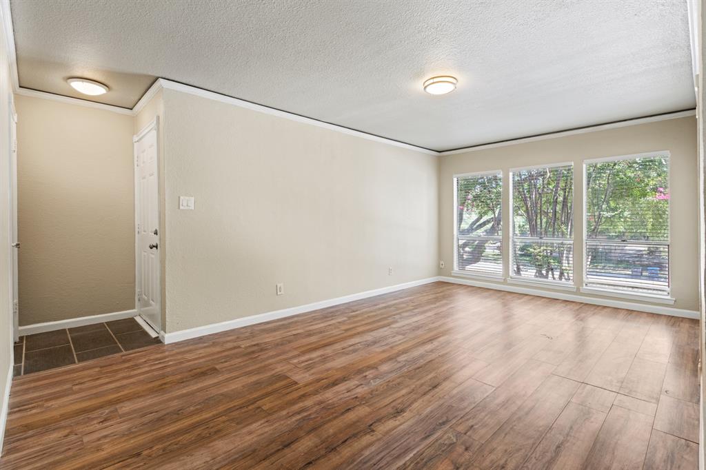 5634 Boca Raton Boulevard, Unit 209 Fort Worth, TX 76112 - Photo 1 of 24 a view of empty room with wooden floor and fan