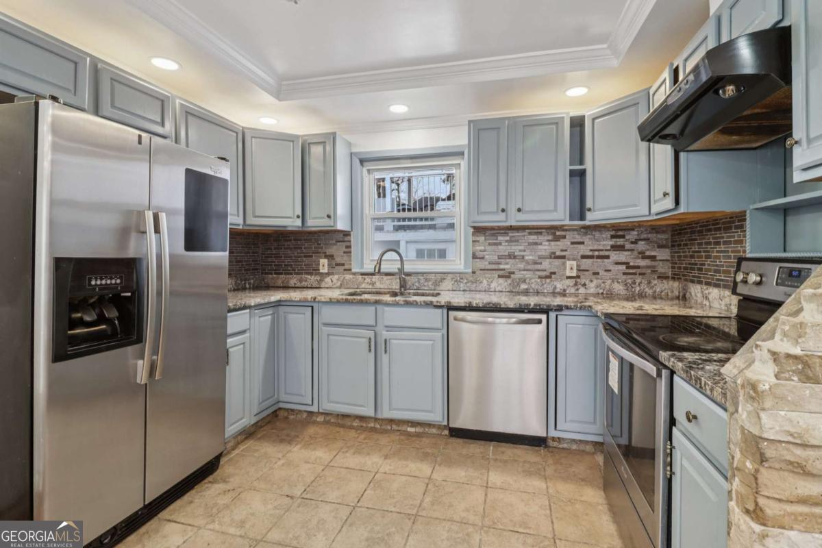 716 Carolina Roads Marietta, GA 30008 - Photo 18 of 54 a kitchen with stainless steel appliances granite countertop a refrigerator sink and stove