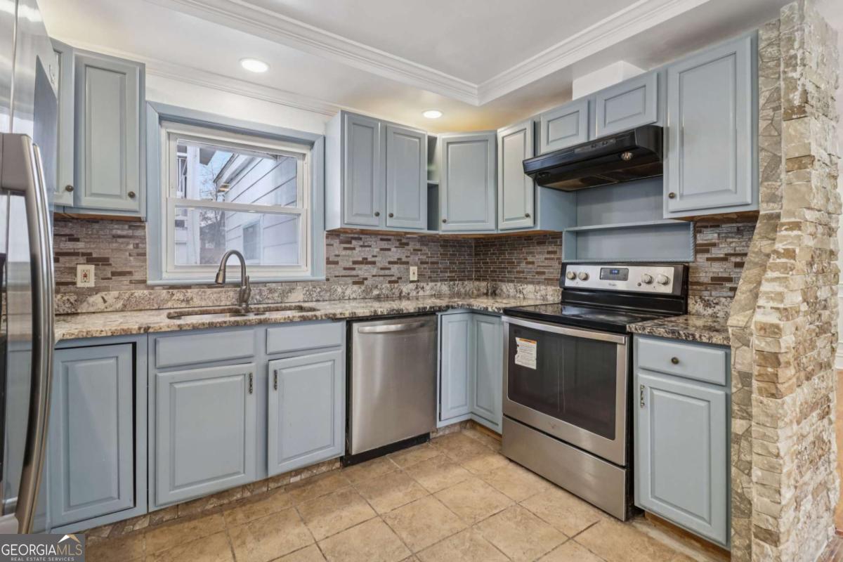 716 Carolina Roads Marietta, GA 30008 - Photo 19 of 54 a kitchen with stainless steel appliances granite countertop a sink stove and microwave