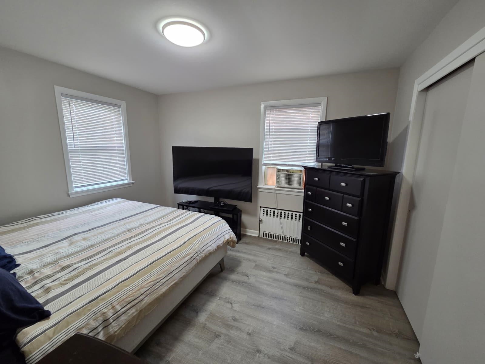166 Carmita Avenue, Unit 2 Rutherford, NJ 07070 - Photo 10 of 27 a bedroom with a bed and a television