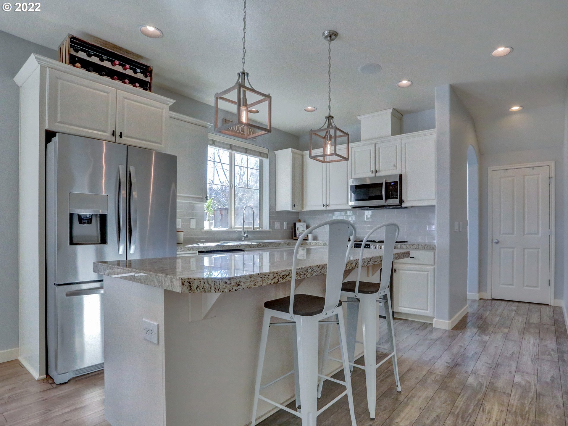 1098 Epperly Way West Linn, OR 97068 - Photo 6 of 32 a kitchen with stainless steel appliances kitchen island granite countertop a refrigerator a stove a sink and white cabinets with wooden floor