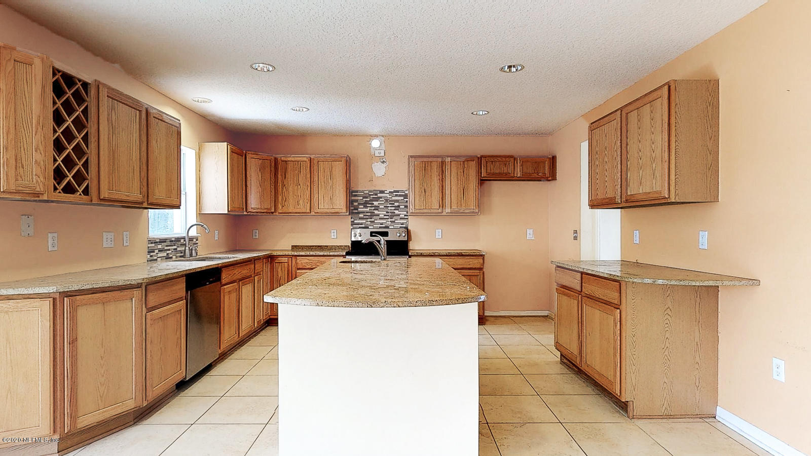 11939 Iron Creek Road Jacksonville, FL 32218 - Photo 7 of 45 a kitchen with stainless steel appliances granite countertop a sink counter space cabinets and a large window