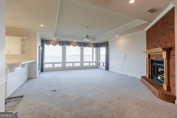 a view of an empty room with a fireplace and a window