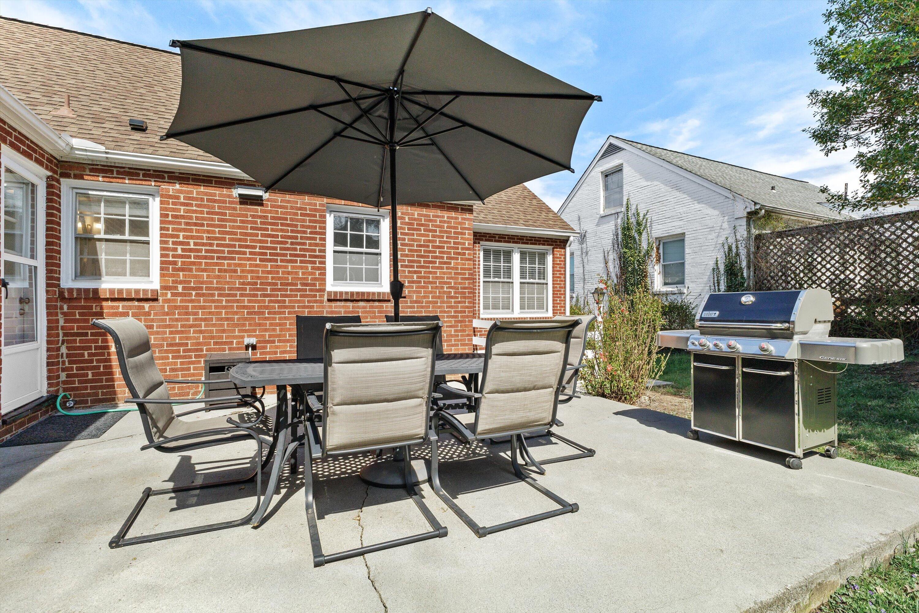 2650 Laburnum Avenue Southwest Roanoke, VA 24015 - Photo 34 of 37 a view of a patio with a dining table and chairs under an umbrella