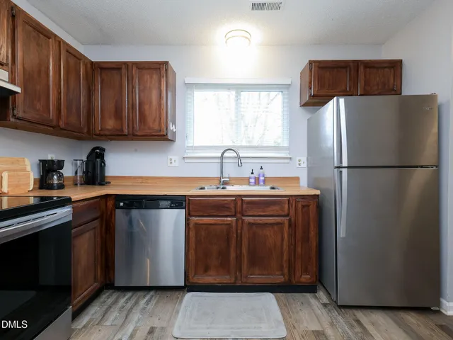 a kitchen with stainless steel appliances granite countertop a refrigerator sink and cabinets