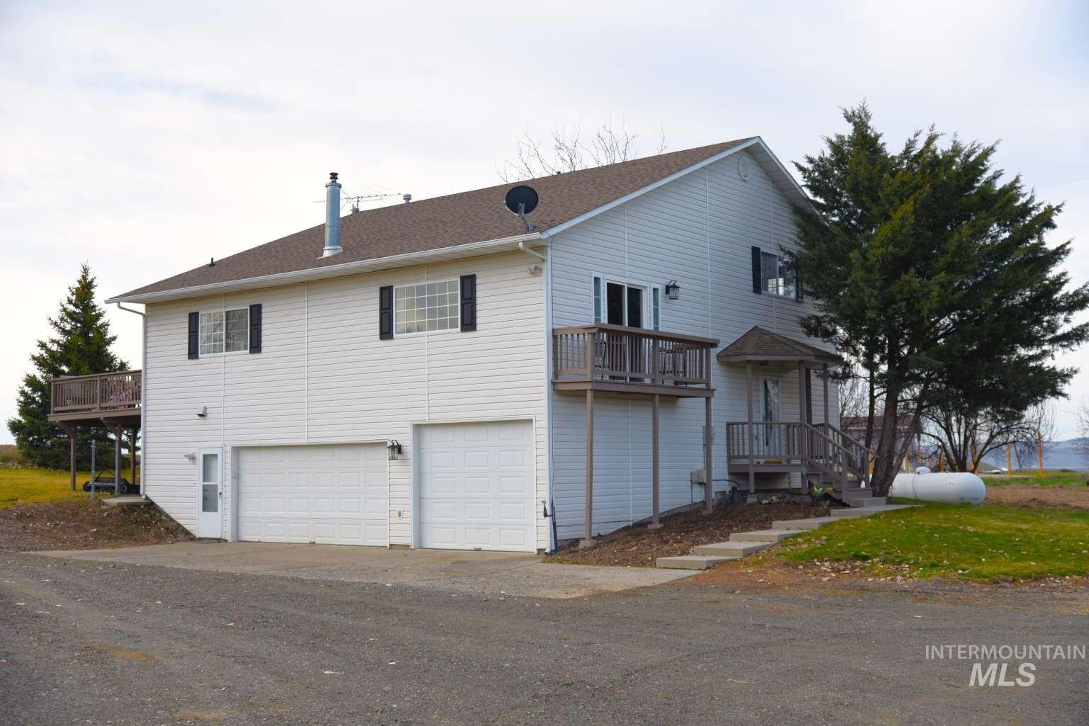 View of front of home featuring an attached garage, driveway, and a chimney