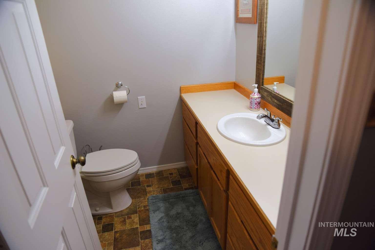 1065 Loafer Lane Weiser, ID 83672 - Photo 22 of 36 Half bath with stone finish floors and vanity