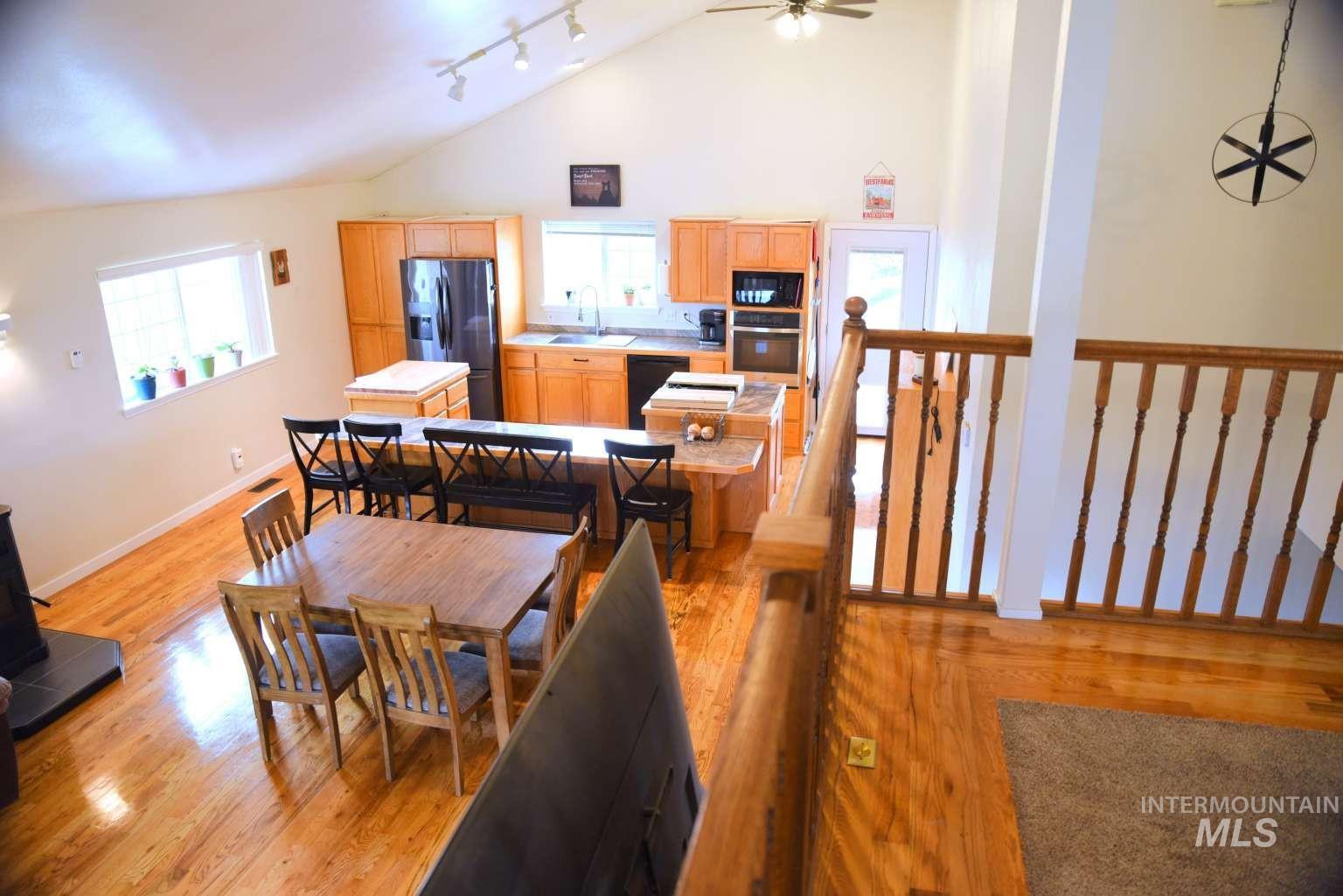 1065 Loafer Lane Weiser, ID 83672 - Photo 34 of 36 Dining room featuring light wood-style flooring, track lighting, ceiling fan, and lofted ceiling