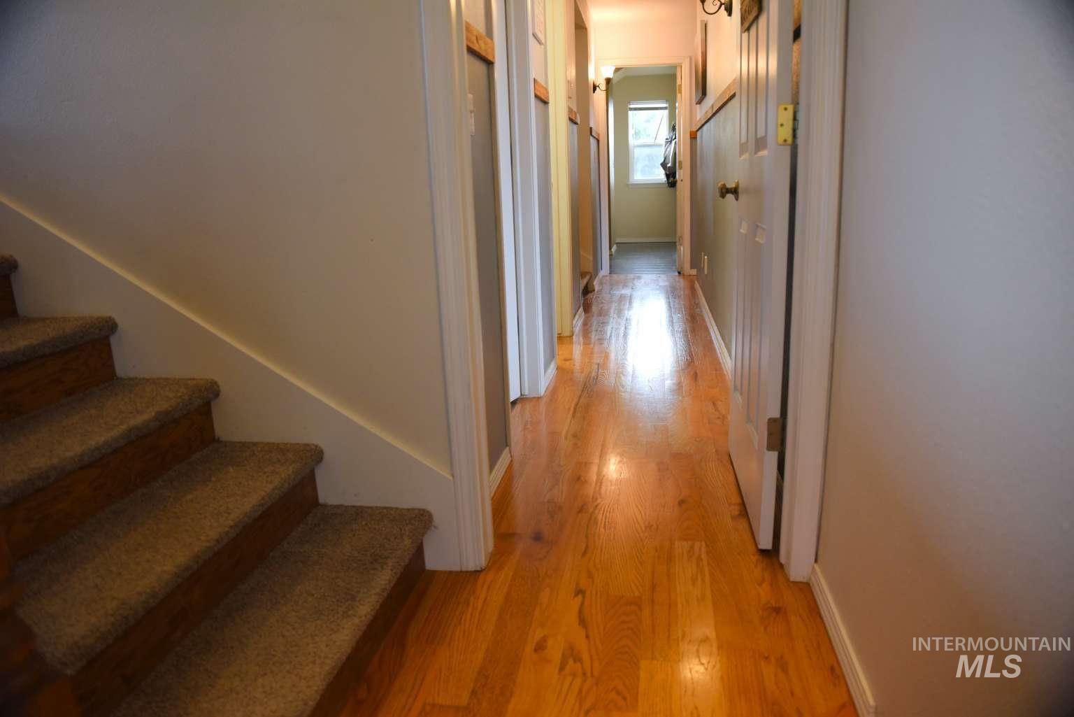 1065 Loafer Lane Weiser, ID 83672 - Photo 7 of 36 Corridor featuring stairway and light wood-style floors