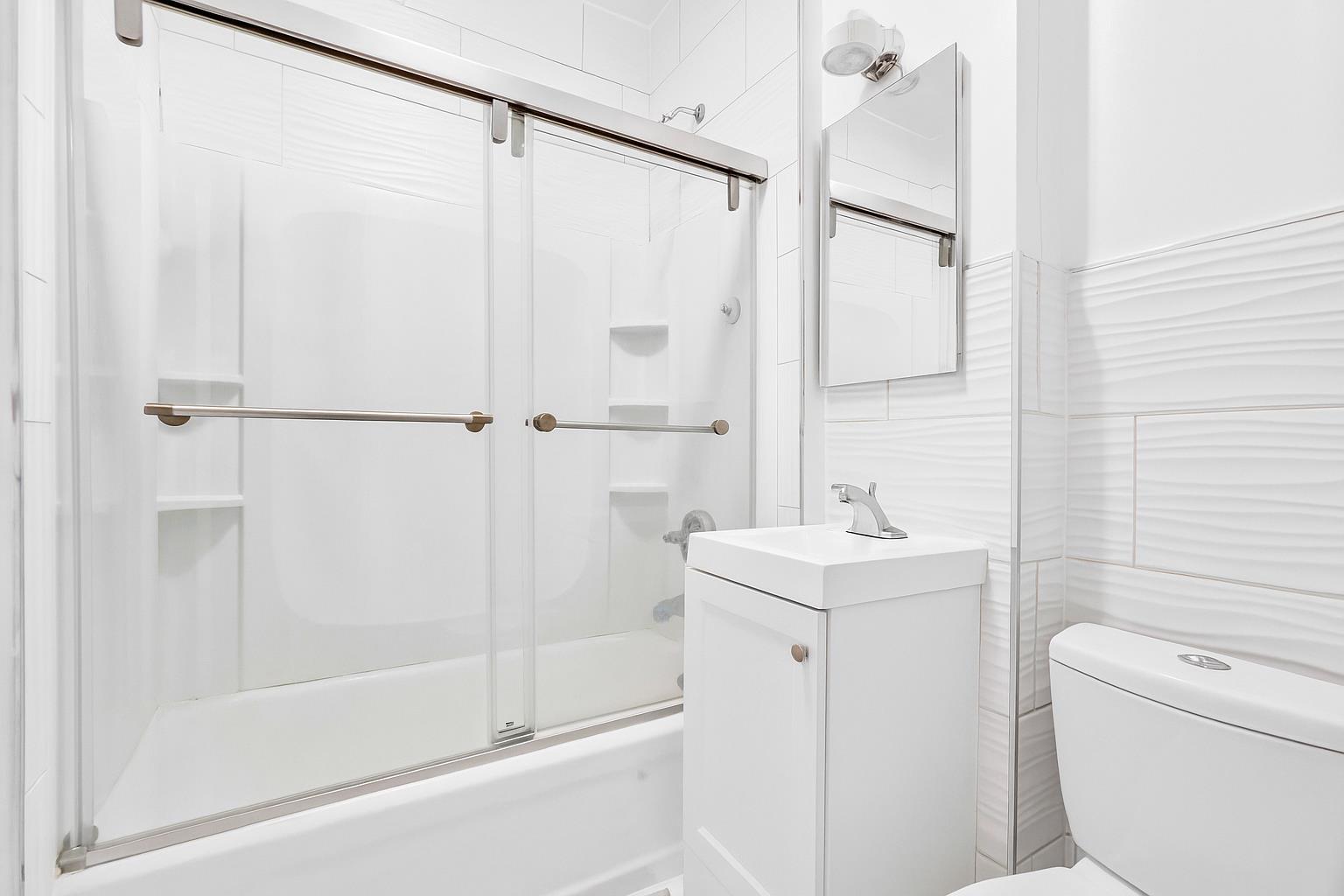 34-20 83rd Street, Unit 4F Queens, NY 11372 - Photo 10 of 12 a bathroom with a sink a toilet and shower