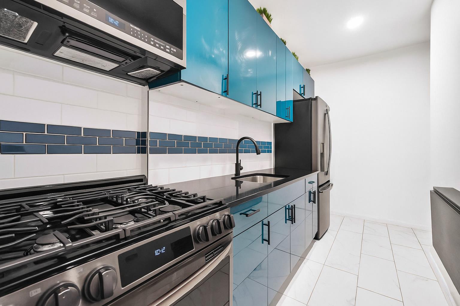 34-20 83rd Street, Unit 4F Queens, NY 11372 - Photo 8 of 12 a kitchen with stainless steel appliances granite countertop a stove and a sink