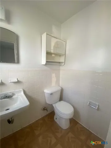 a bathroom with a toilet a sink and mirror
