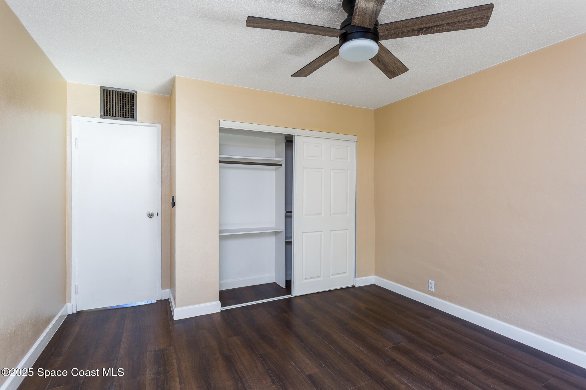 1700 Atlantic Street, Unit 9 Melbourne Beach, FL 32951 - Photo 11 of 30 an empty room with wooden floor closet and windows