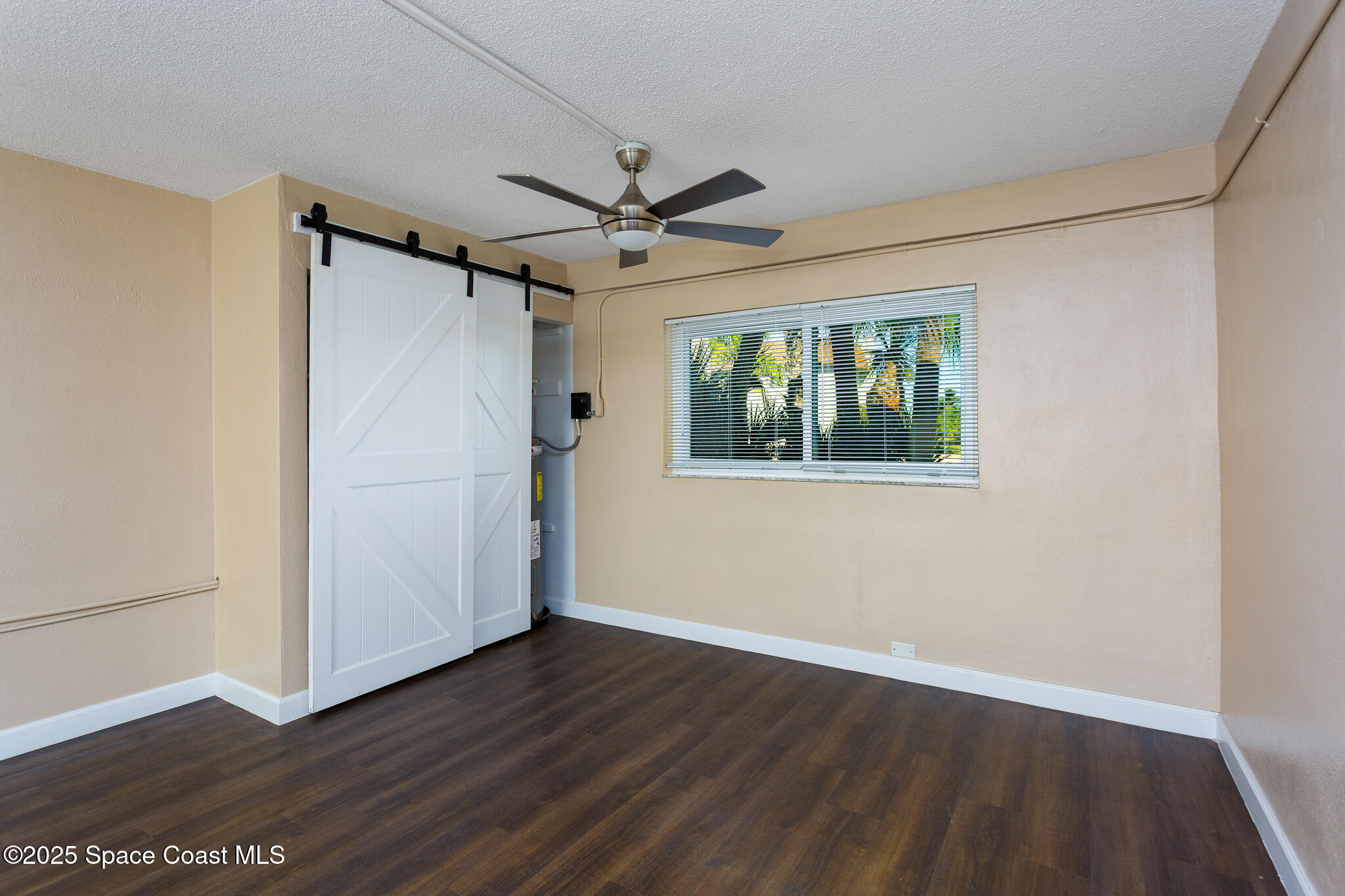 1700 Atlantic Street, Unit 9 Melbourne Beach, FL 32951 - Photo 12 of 30 a view of empty room with wooden floor and fan