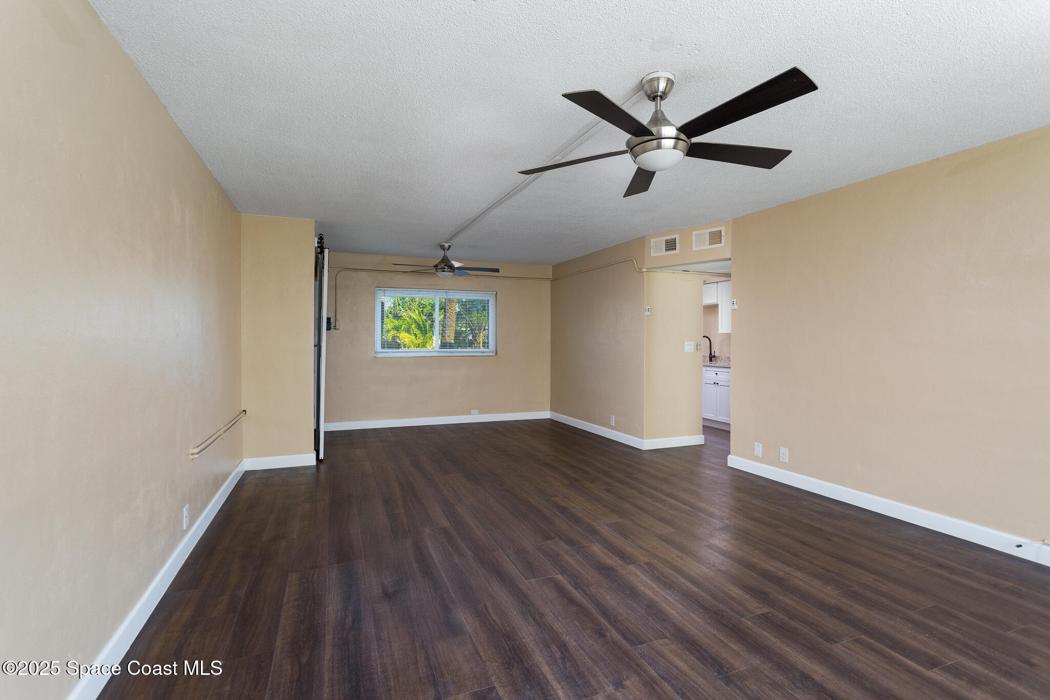 1700 Atlantic Street, Unit 9 Melbourne Beach, FL 32951 - Photo 13 of 30 an empty room with wooden floor and windows