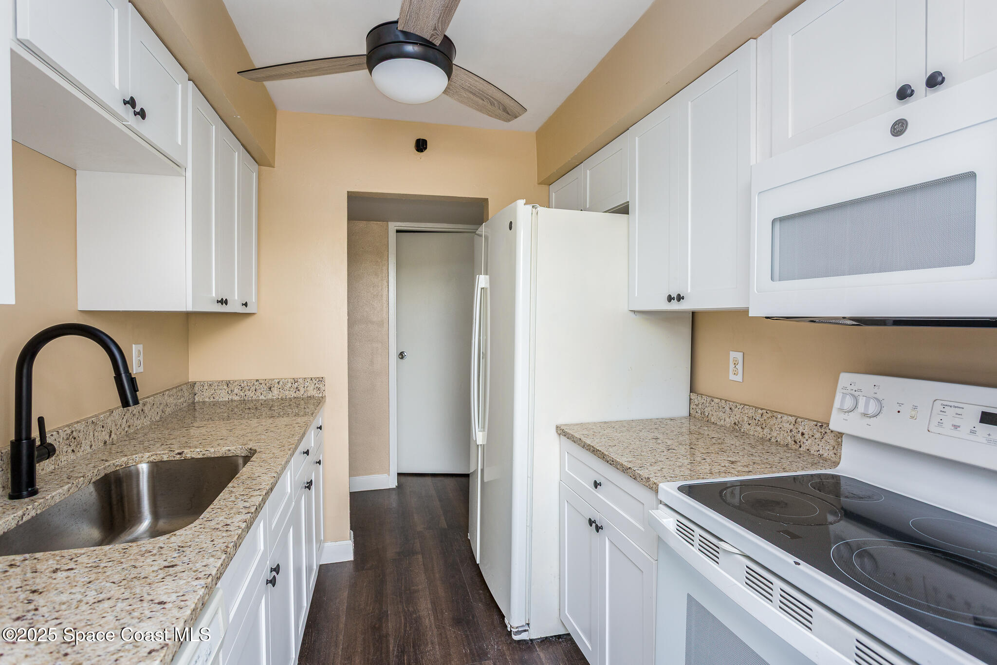 1700 Atlantic Street, Unit 9 Melbourne Beach, FL 32951 - Photo 7 of 30 a kitchen with stainless steel appliances granite countertop a sink stove and refrigerator