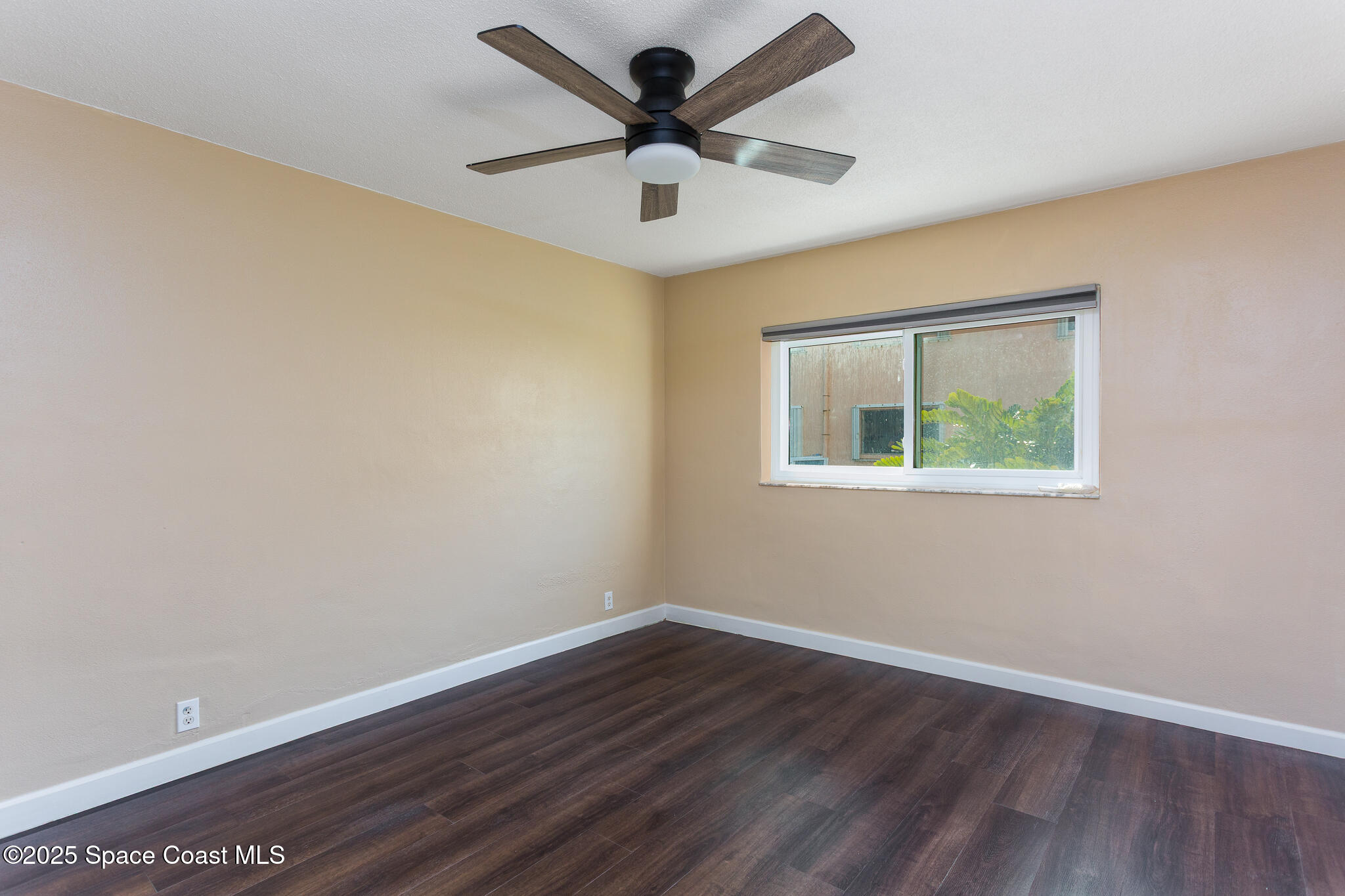 1700 Atlantic Street, Unit 9 Melbourne Beach, FL 32951 - Photo 10 of 30 a view of an empty room with window and wooden floor