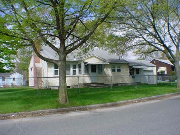 a front view of a house with a garden and trees