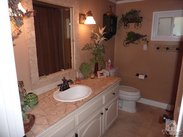 2430 Invar Court Simi Valley, CA 93065 - Photo 12 of 26 a bathroom with a granite countertop sink a toilet and mirror