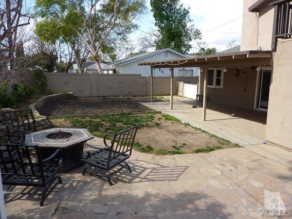2430 Invar Court Simi Valley, CA 93065 - Photo 25 of 26 a view of a patio with table and chairs under an umbrella with trees