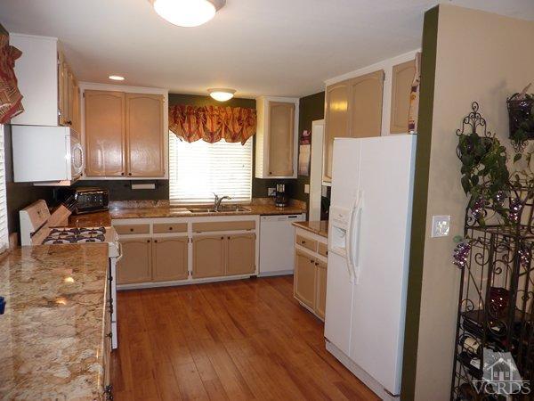 2430 Invar Court Simi Valley, CA 93065 - Photo 4 of 26 a kitchen with a refrigerator a sink and cabinets