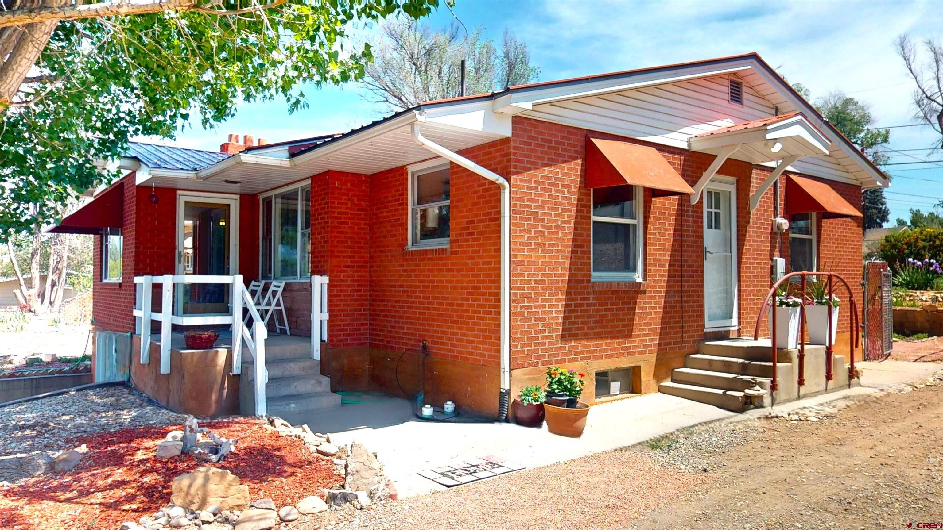a backyard of a house with barbeque oven table and chairs